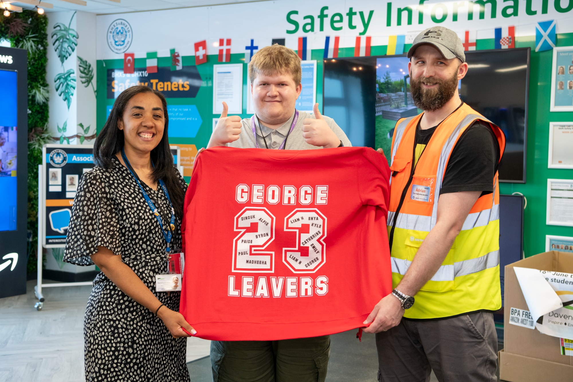 People holding a leavers' shirt that students have made